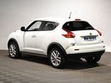 the rear end of a white nissan juke suv parked in a garage