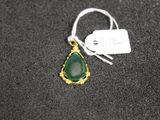 a close up of a necklace with a green stone on it