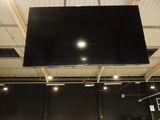 a large television hanging from the ceiling in a room