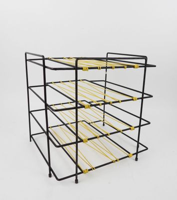 a black and yellow wire rack with six bottles of wine