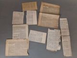 several pieces of old newspaper are laying on a table