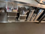 many pans and pans sitting on a shelf in a kitchen