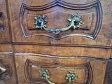 a wooden chest of drawers with brass handles on it