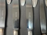 five knives and a knife holder on a table