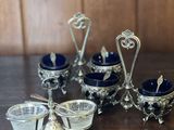 un ensemble de plats en verre argenté et bleu posés sur une table en bois
