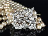 pearl and diamond broochle with pearls on a black surface