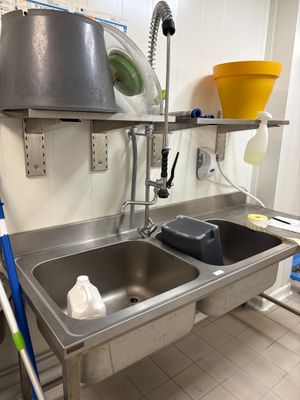 une cuisine avec un évier et une serpillière posée sur le plan de travail