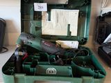 une boîte à outils verte contenant des outils, posée sur un plan de travail