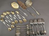 several silver spoons, forks and spoons laid out on a table
