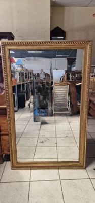 a large mirror sitting on the floor in a store
