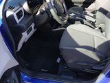 the interior of a car with the door open and the driver ' s seat down