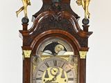 a clock that is sitting on a stand with angels on it