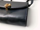 a black purse with a gold clasp on it