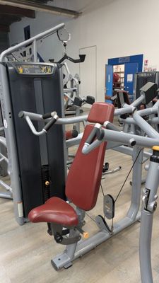 a gym room with a row of machines and other equipment