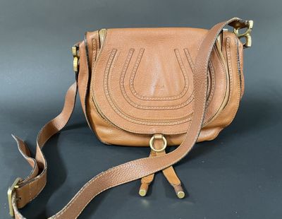 a close up of a brown purse on a black surface