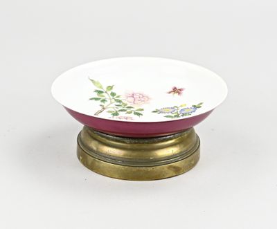 un petit bol posé sur un socle et orné d'un motif floral