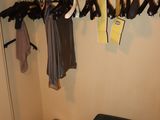 a closet with clothes and a suitcase in it