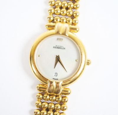 une image d'un gros plan d'une montre-bracelet sur une surface blanche