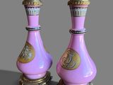 pair of pink and gold vases on stand on grey background