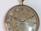 une montre de poche en or avec des chiffres romains sur le cadran