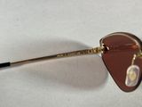 sunglasses with a gold frame and brown lenses on a white surface