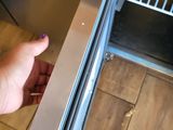 a person that is opening an oven door to take something out of the oven