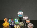 de nombreux objets en verre de différentes couleurs posés sur une table
