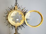 a gold sunburst and a mirror on a stand