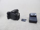 un appareil photo et une clé USB posés l'un à côté de l'autre sur une table