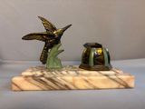 a statue of a bird and a helmet on a marble base