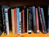 many books that are on a wooden shelf