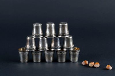 a stack of silver cups with pencils next to them