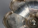 an antique silver plate with a flower shaped design on it
