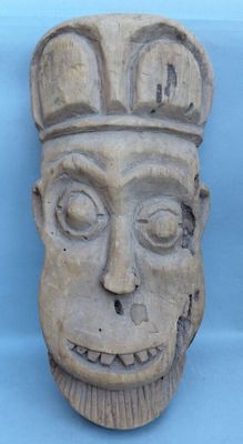 une image représentant un masque en pierre surmonté d'une couronne