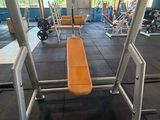 an image of a gym room with a bench and weights
