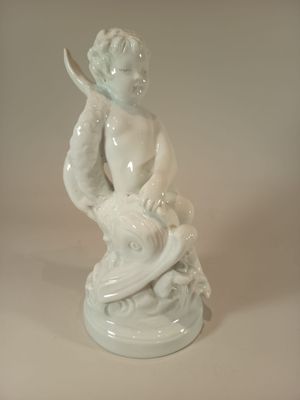 a figurine of a boy holding a knife in his hand