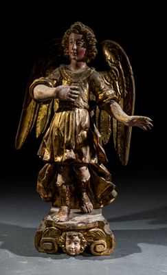 statue d'un ange tenant un oiseau, posée sur un socle dans une pièce sombre