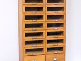 une armoire en bois comportant de nombreux tiroirs et surmontée de tiroirs