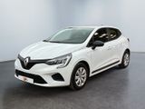 Une voiture blanche est garée dans une pièce au sol noir.