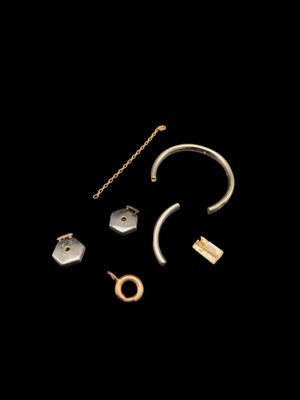 un gros plan sur une paire de boucles d'oreilles et une chaîne sur fond noir