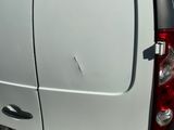 une camionnette blanche qui a un trou sur le côté