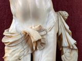 a statue of a woman on a red surface