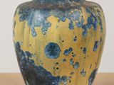 a blue and yellow vase sitting on a table