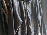 une veste en cuir suspendue à un portant devant une vitrine