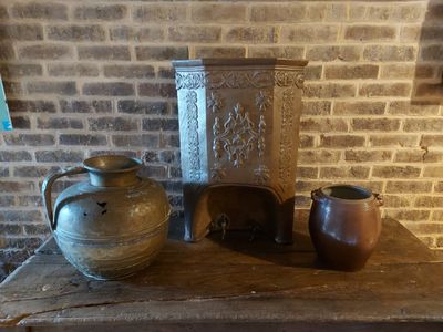 trois vases posés sur une table, avec un mur de briques en arrière-plan