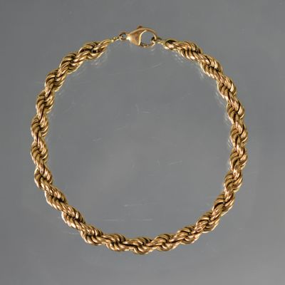 un collier en or composé d'une corde torsadée suspendue à une chaîne