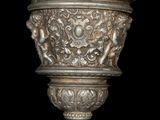 a silver vase with a design on it on a black background