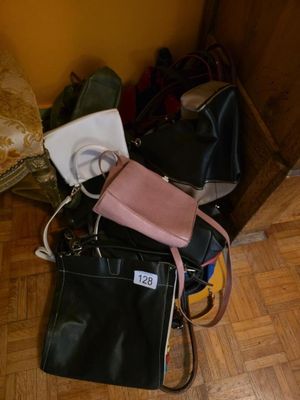 several purses are stacked on top of each other on a wooden floor