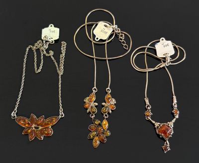 un lot de quatre colliers ornés de breloques en forme de papillon