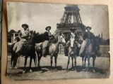 several people are riding horses in front of the eiffel tower
